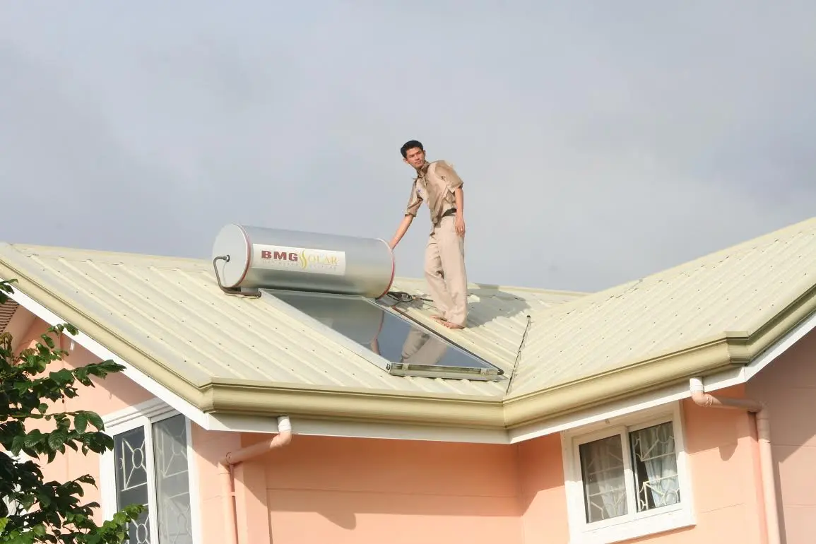Picture of man on rooftop installing hot water system